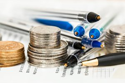 Coins and pens next to each other on top of paper work