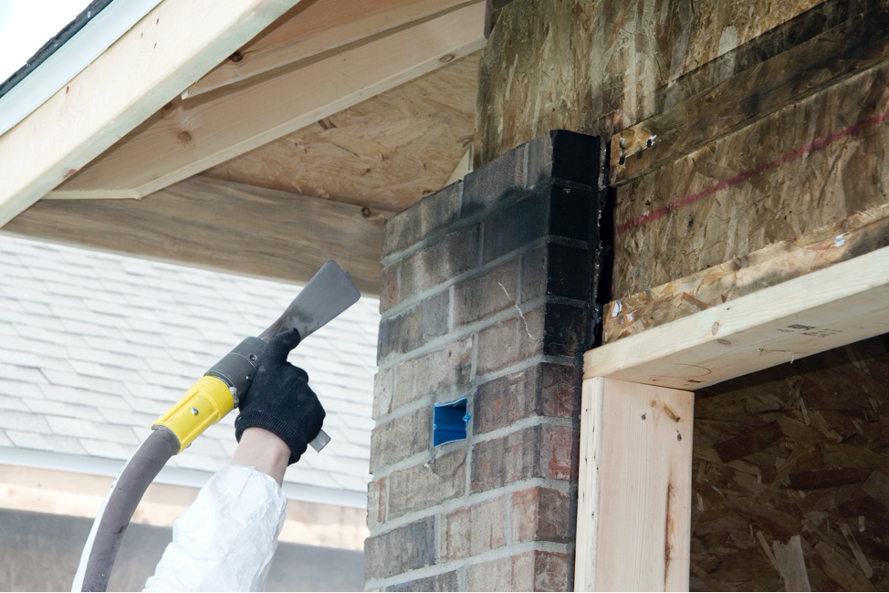 man using tool to clean off fireplace